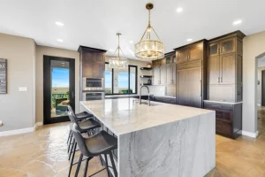 Modern kitchen with marble island and dark wood cabinets, showcasing whole-home remodeling services in Colorado Springs