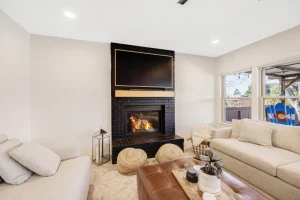Modern family room with fireplace, neutral sofas, and natural light